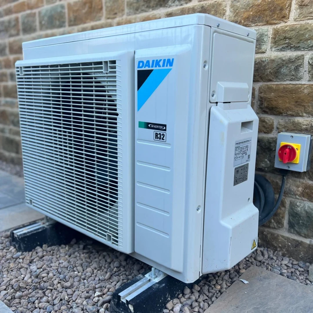 Daikin air conditioning outdoor unit installed against a brick wall